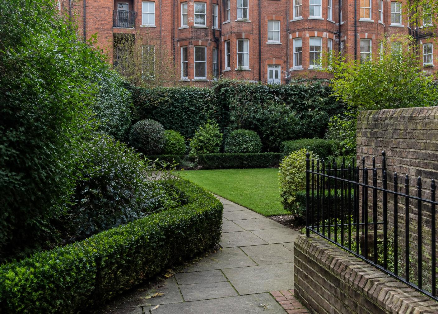 Communal courtyard garden behind a red-brick London mansion block